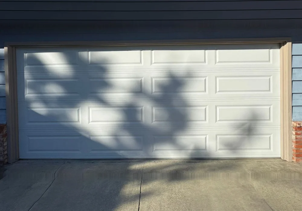 The same opening fitted with a new white raised-panel garage door