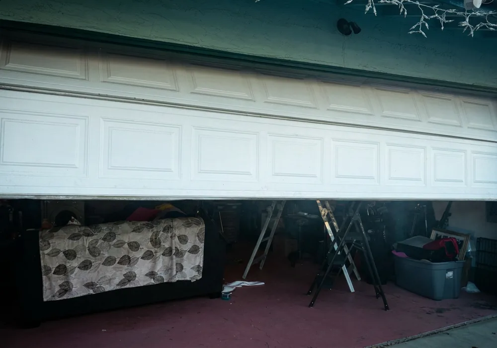 Garage door hanging crooked and jammed partway open